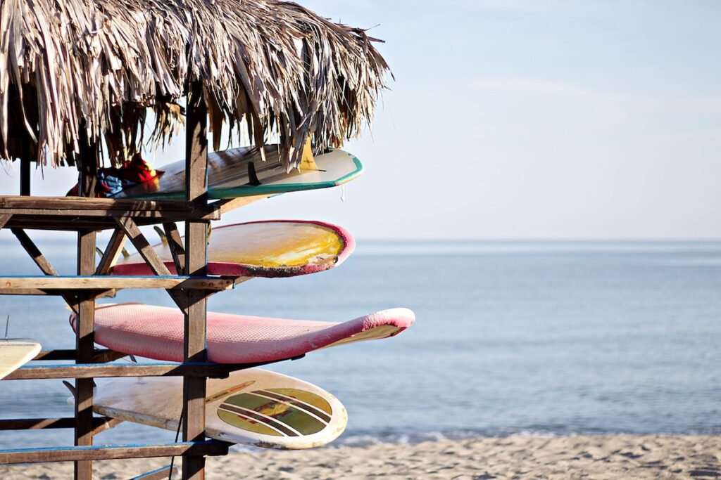 longboards rangés sur un rack sur la plage