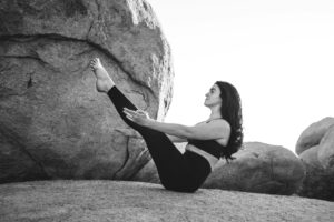 Woman doing boat pose, one of the best exercises for surfing