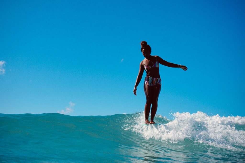 Female surfer on a longboard with toes on the nose
