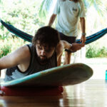 A picture showing a surfer practicing his pop-up on land to perfect his technique.