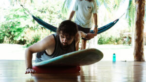 A picture showing a surfer practicing his pop-up on land to perfect his technique.
