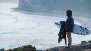 A surfer getting ready to surf in cold water that will boost the immune system.