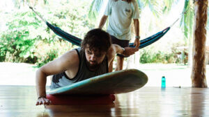 A picture showing a surfer practicing his pop-up on land to perfect his technique.