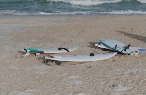 PU surfboards lying in the sand close to the ocean