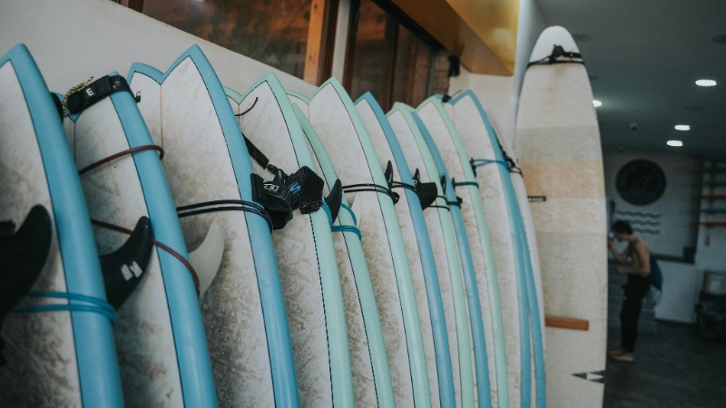 line of fish shaped surfboards in a row to demonstrate the difference of Pu boards vs. epoxy surfboards