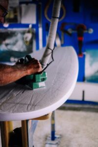 shaping a PU surfboard by shaping down the foam blank