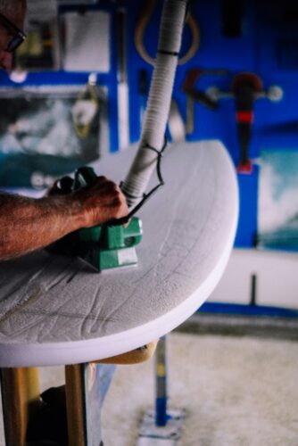 shaping a PU surfboard by shaping down the foam blank