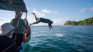 Surfer jumping off the boat for to go surfing with Surf Expedition surf camp in Costa Rica